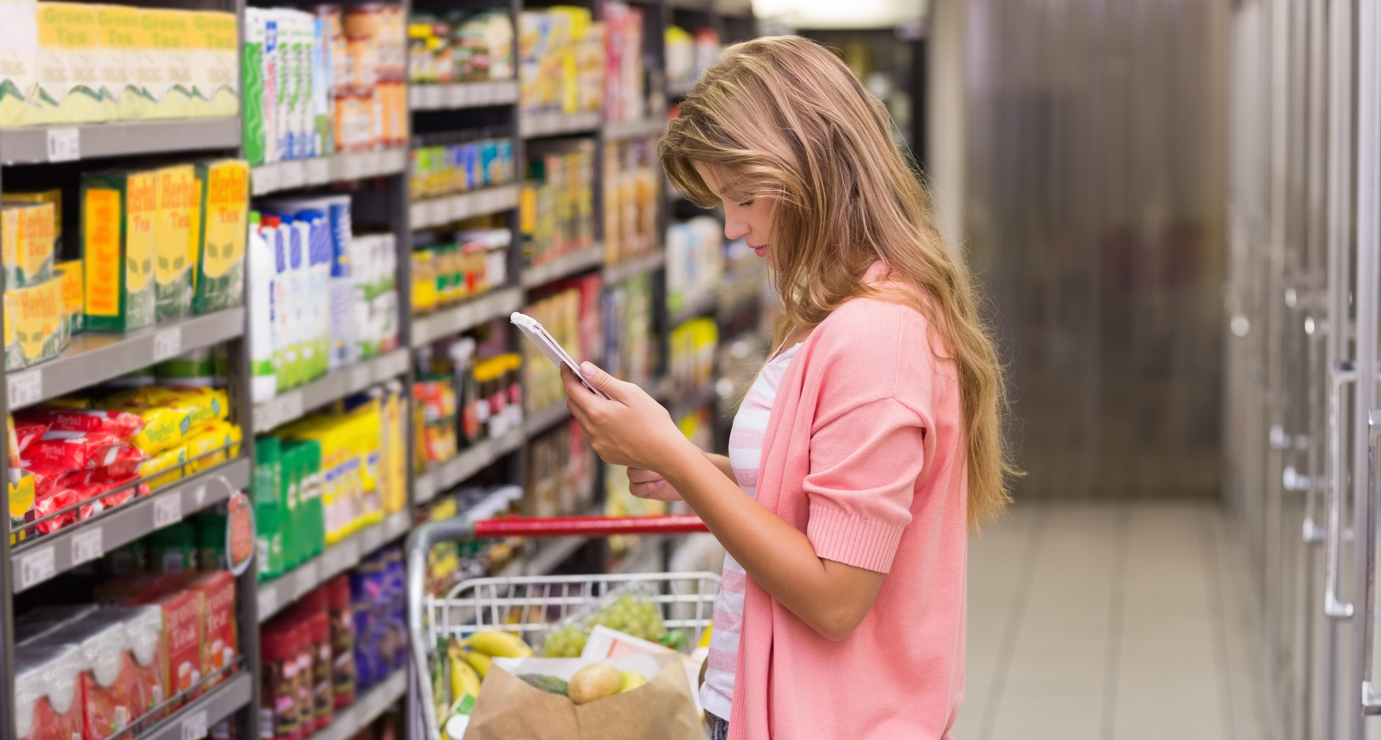 a lady looks at her phone in a grocery store